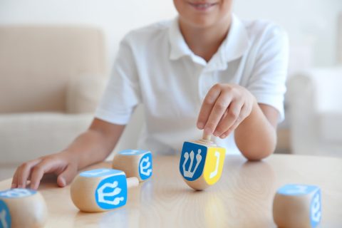 Jewish Boy Playing With Dreidel At Home